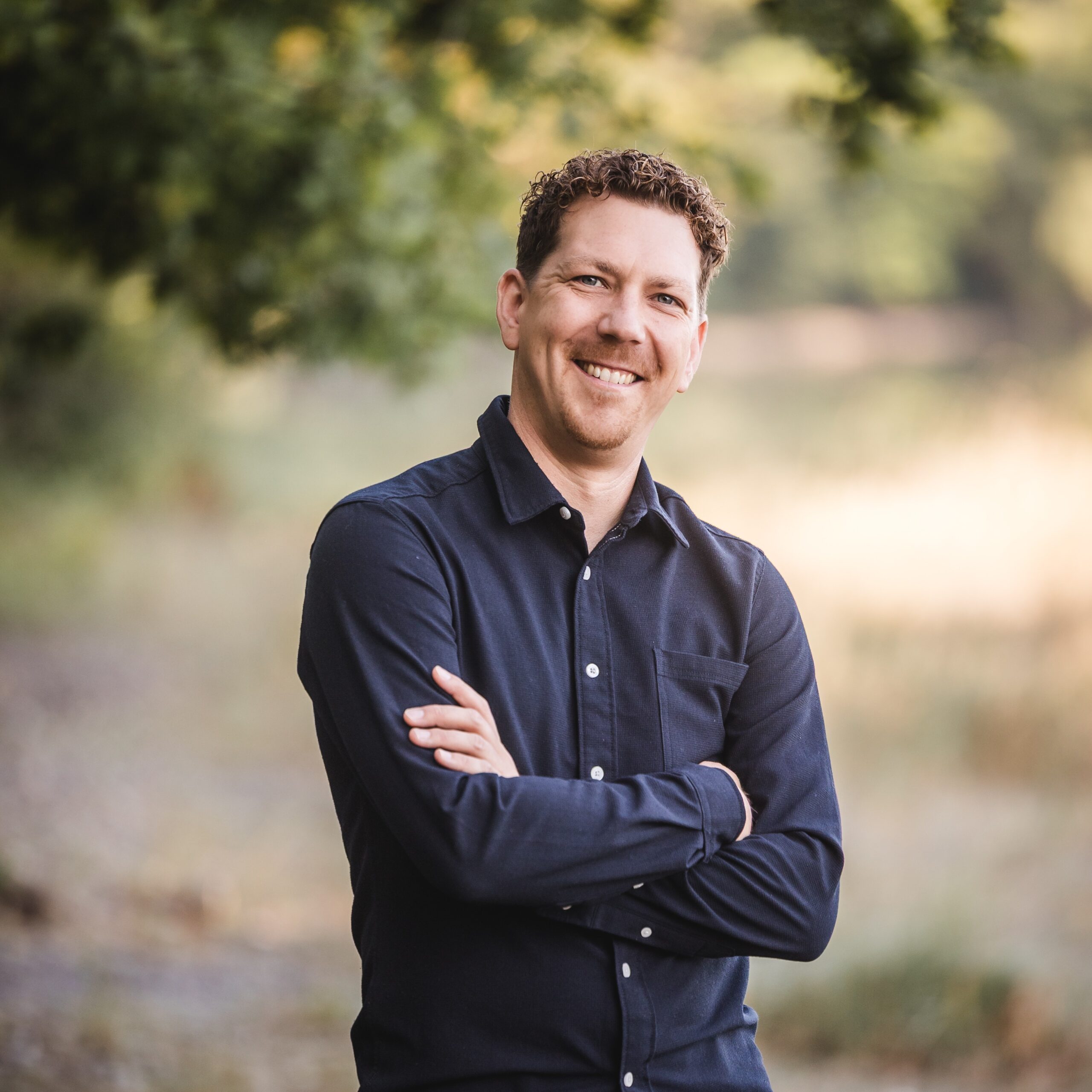 Michael Thiess im dunklen Hemd vor grüner Landschaft